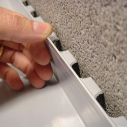 A contractor in Washington installing a perimeter drain tile system during a sump pump installation.