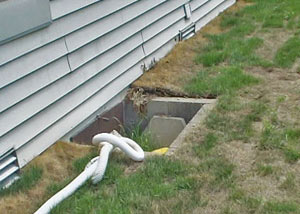 The ugly, old concrete window well of a Sparta crawl space