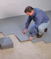 Contractors installing basement subfloor tiles and matting on a concrete basement floor in East Stroudsburg, New Jersey and Pennsylvania